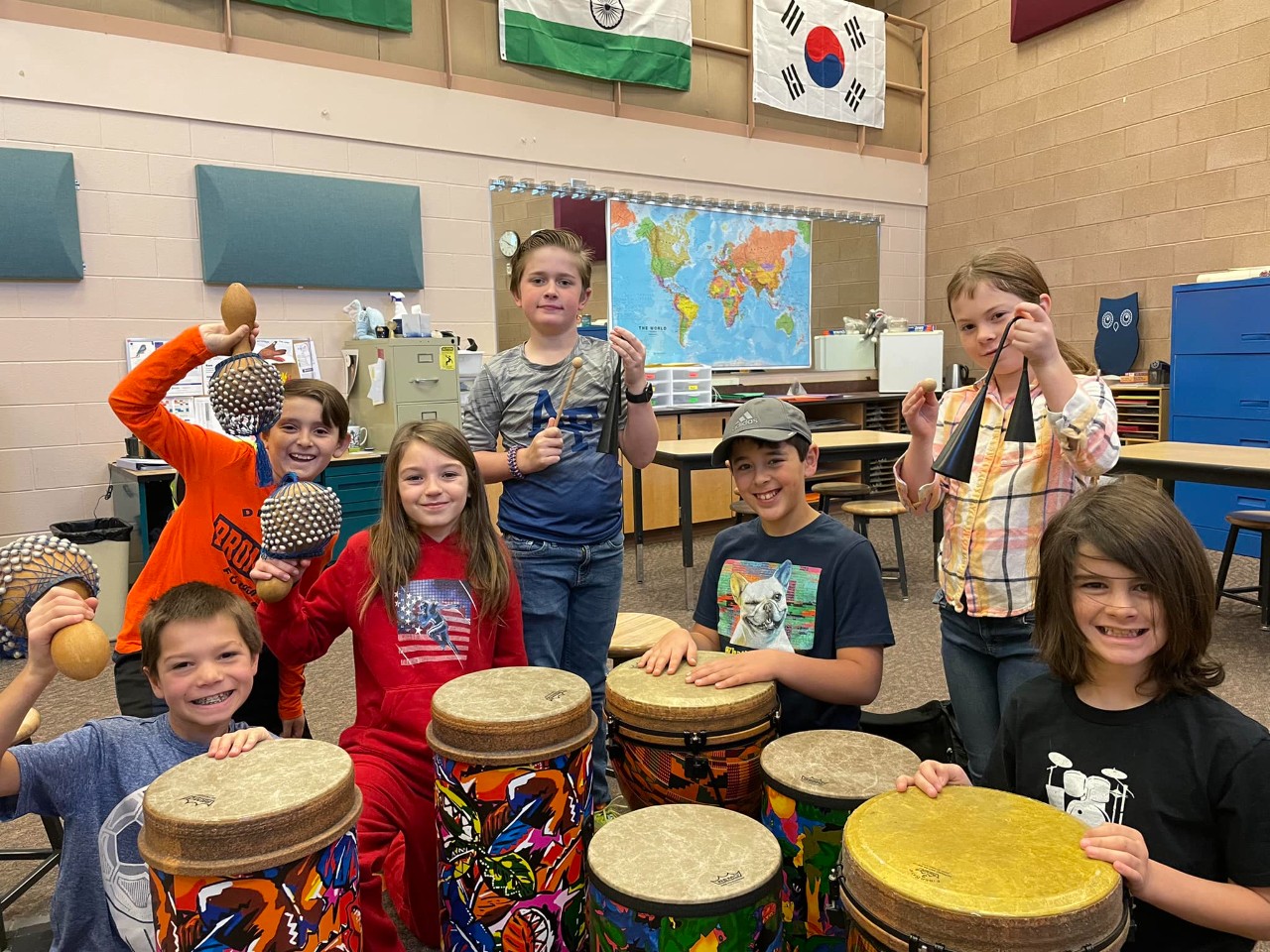 Students in Drumming Dragons Club posing with a variety of drums.